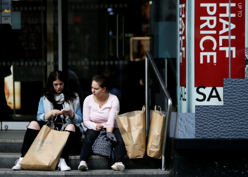 © Reuters. Two shoppers sit with their bags on Oxford Street in London