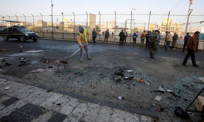 © Reuters. Iraqi security forces inspect the site of a bomb attack in Baghdad