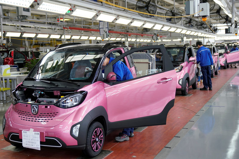 © Reuters. FILE PHOTO: Workers inspect Baojun E100 all-electric battery cars at a final assembly plant operated by General Motors Co and its local joint-venture partners in Liuzhou