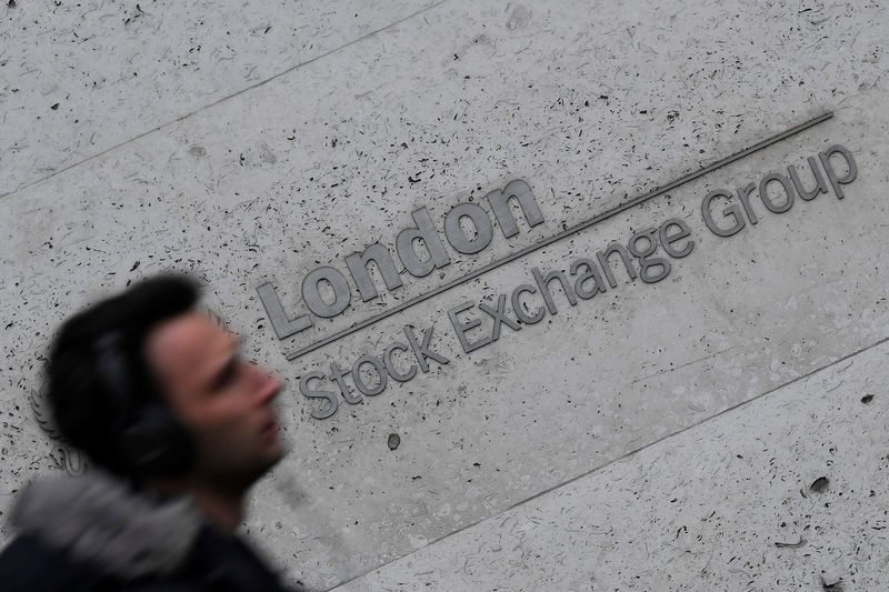 © Reuters. FILE PHOTO - People walk past the London Stock Exchange Group offices in the City of London, Britain