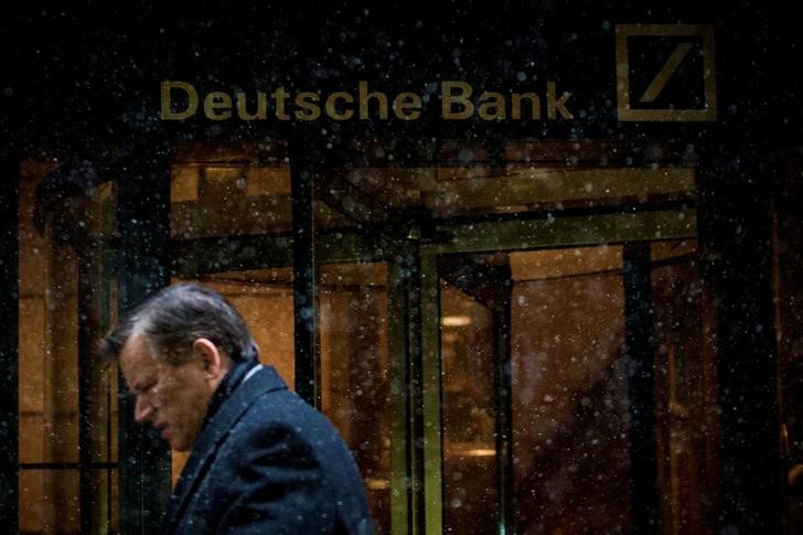 © Reuters. A man walks past the Deutsche Bank offices during a snow storm in Manhattan's financial district in New York