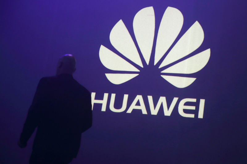 © Reuters. FILE PHOTO - A man walks past a logo during the presentation the Huawei's new smartphone, the Ascend P7, launched by China's Huawei Technologies in Paris
