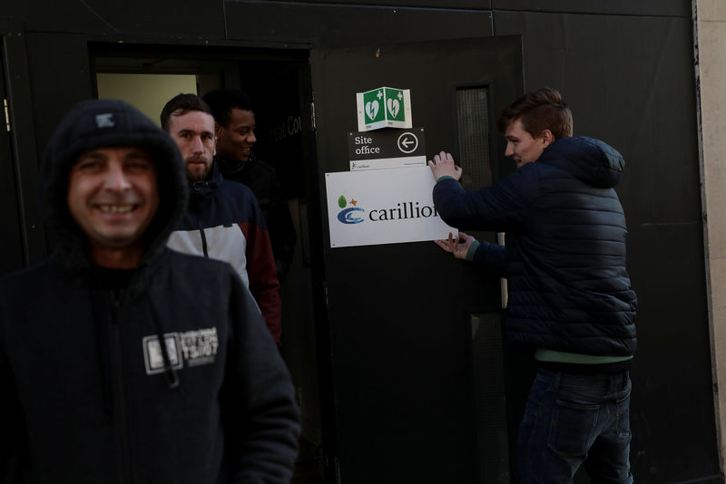 © Reuters. A worker pretends to remove a Carillion logo at the site office of a construction project in central London