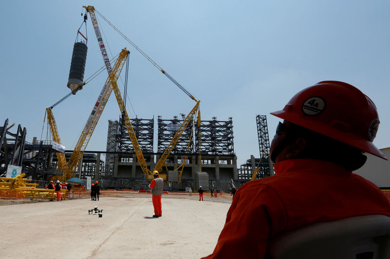 © Reuters. FILE PHOTO: Worker looks at a crane moving a new coke drum to be collocated in a platform at the Mexico's state-owned company Pemex refinery in Tula