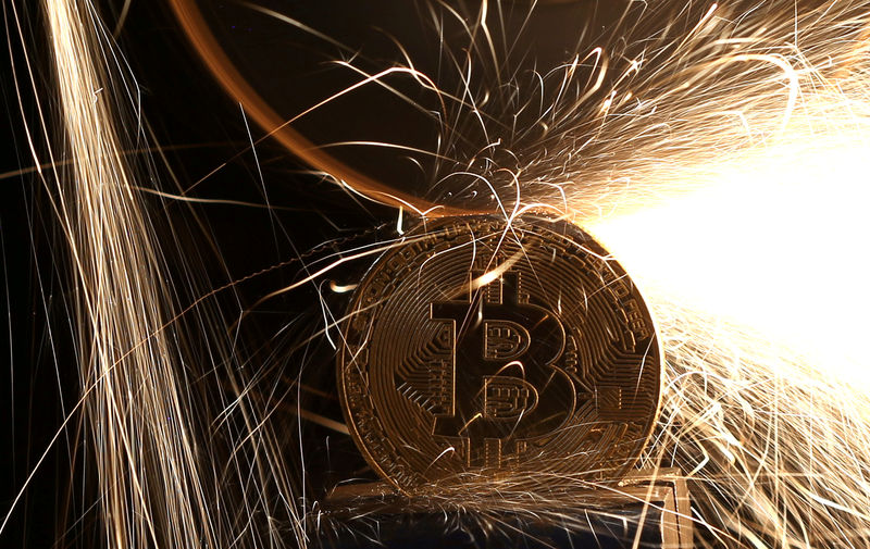 © Reuters. FILE PHOTO: Sparks glow from broken Bitcoin (virtual currency) coins in this illustration picture