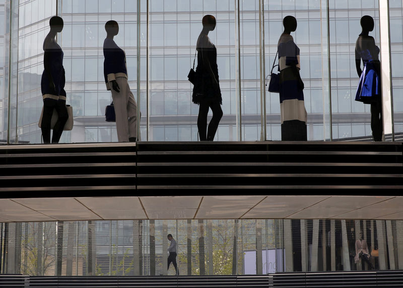 © Reuters. FILE PHOTO: A man is seen walking under mannequins at a shopping mall in Beijing