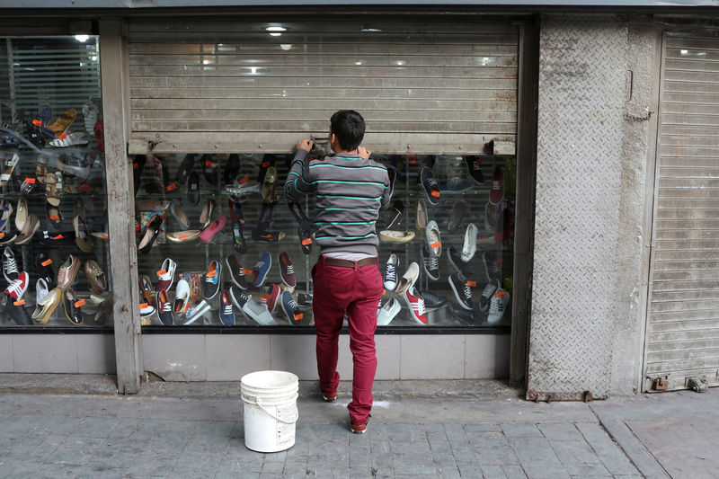 © Reuters. Funcionário fecha loja de sapatos no centro de Caracas, na Venezuela