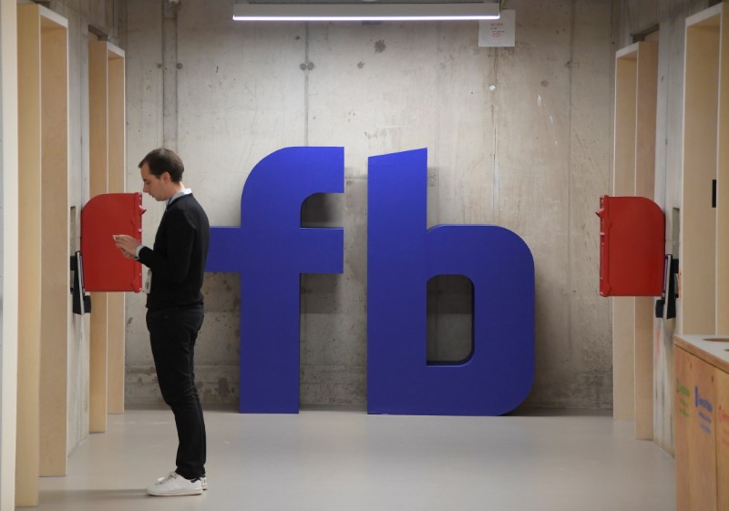© Reuters. A man waits for an elevator in front of a logo at Facebook's headquarters in London