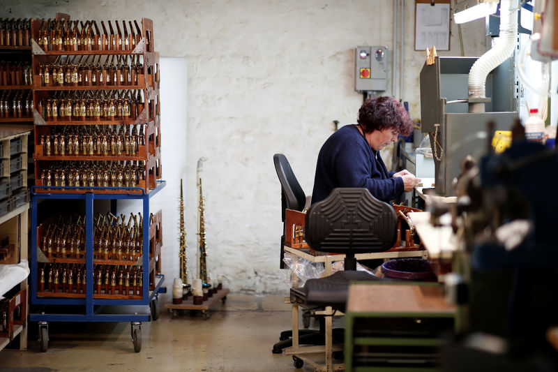 © Reuters. A worker assembles a saxophone at the Henri Selmer wind instruments factory in Mantes-la-Ville near Paris