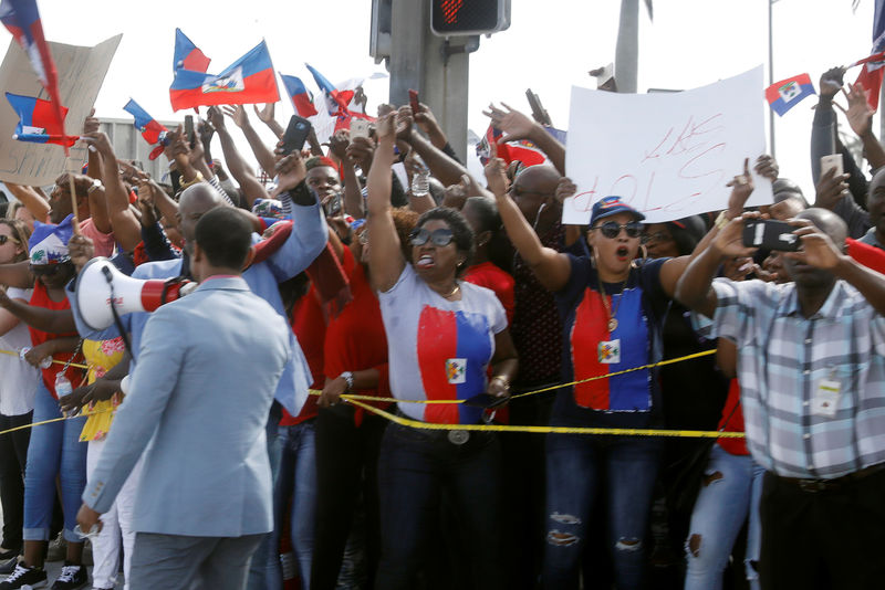 © Reuters. Demonstrators hold signs and shout as Trump motorcade passes in West Palm Beach, Florida