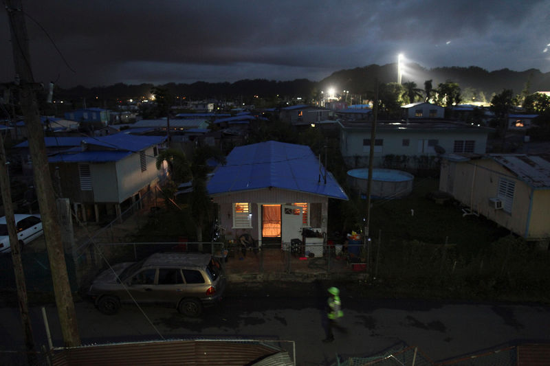 © Reuters. A house is lit up with the help of a generator next to houses in the dark after Hurricane Maria damaged the electrical grid in September, in Dorado