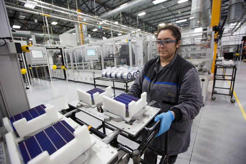 © Reuters. Production operator Diana Correa loads cells into a machine at the SolarWorld solar panel factory in Hillsboro