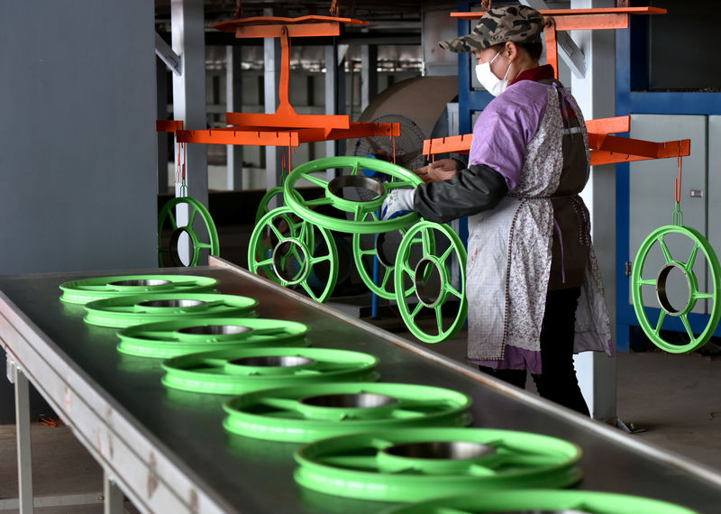 © Reuters. A woman works on a production line of shared bicycle wheels at a plant in Jinhua
