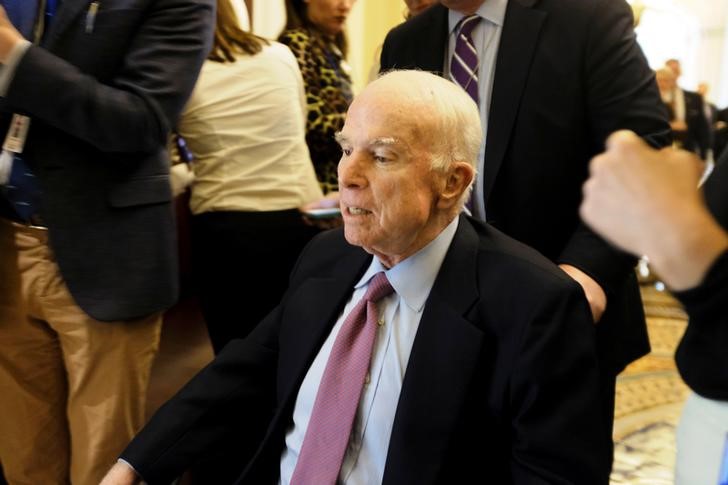 © Reuters. U.S. Senator John McCain (R-AZ) leaves the Senate floor in a wheelchair during debate over the Republican tax reform plan in Washington