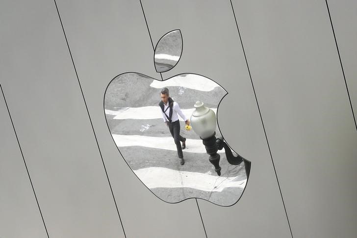 © Reuters. A man is reflected in a Apple store logo in San Francisco