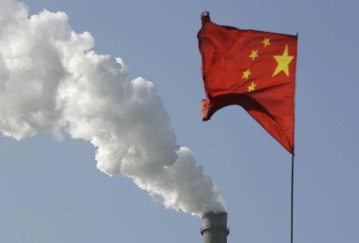 © Reuters. Bandeira da China vista em frente a chaminé de fábrica, em Taiyuan