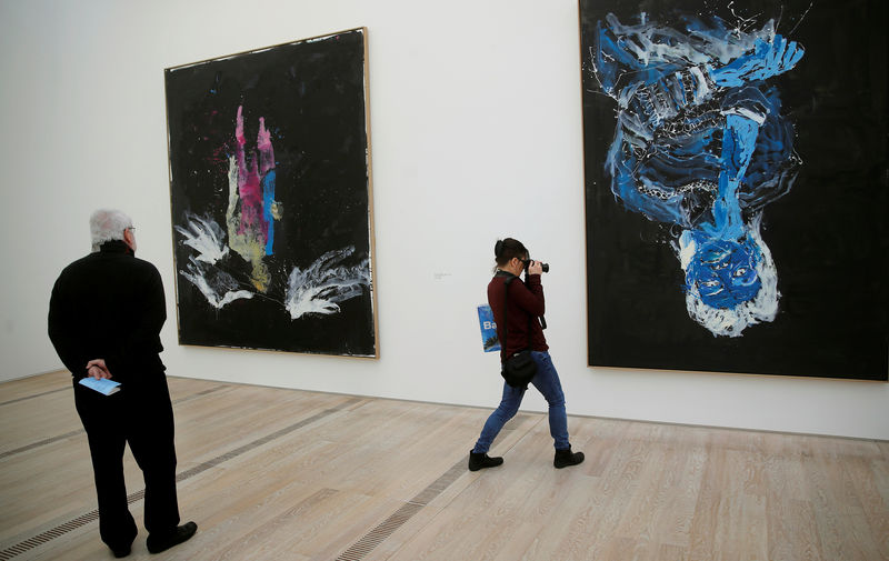 © Reuters. People stand in front of paintings of German artist Baselitz during a media preview of the exhibition 'Baselitz' at the Fondation Beyeler in Riehen