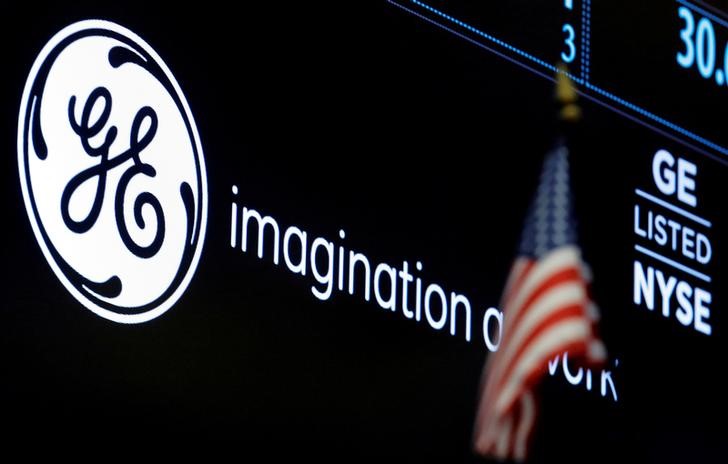© Reuters. FILE PHOTO -The ticker and logo for General Electric Co. is displayed on a screen at the post where it is traded on the floor of the NYSE