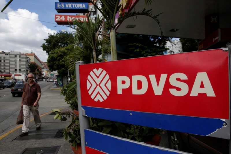 © Reuters. FILE PHOTO: Man walks past PDVSA corporate logo at  gas station in Caracas