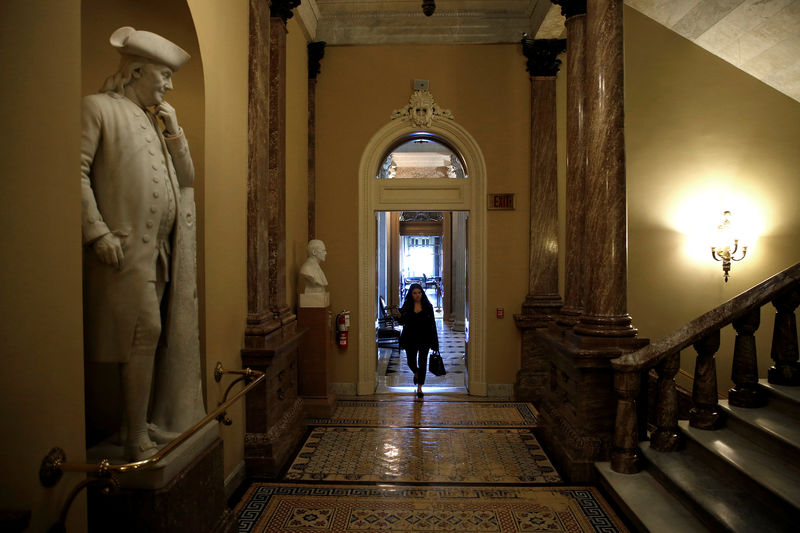 © Reuters. A woman walks past a statue of Benjamin Franklin after President Donald Trump and the U.S. Congress failed to reach a deal on funding for federal agencies on Capitol Hill in Washington