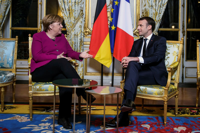 © Reuters. French President Emmanuel Macron and German Chancellor Angela Merkel speak during their meeting at the Elysee Palace in Paris