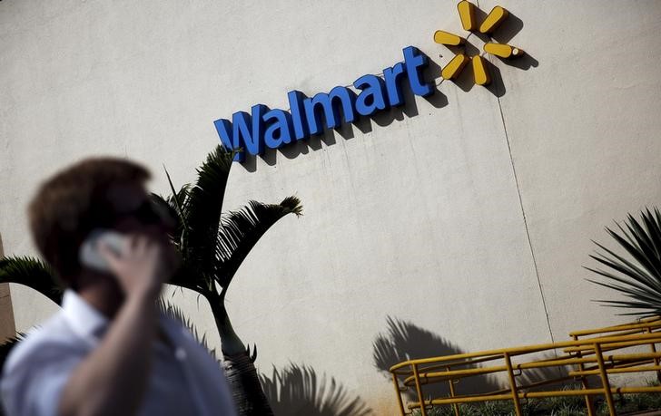 © Reuters. FILE PHOTO -  A man talks on his mobile phone in front of a Wal-Mart store in Sao Paulo