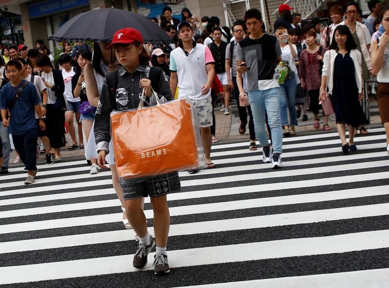 © Reuters. A woman carries a shopping bag at a shopping district in Tokyo