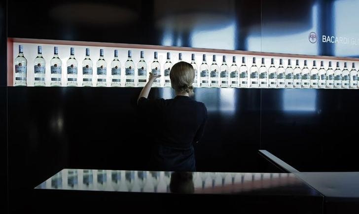 © Reuters. FILE PHOTO -  An exhibitor arranges Bacardi rum bottles during the TFWA exhibition in Cannes