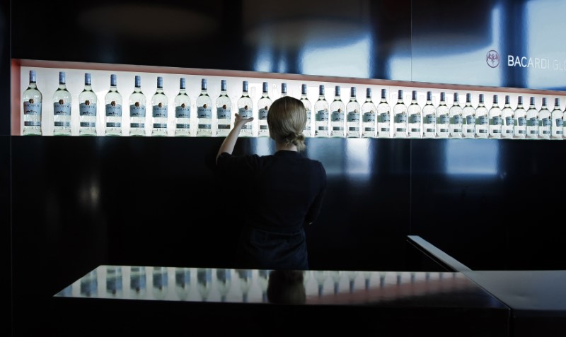 © Reuters. FILE PHOTO -  An exhibitor arranges Bacardi rum bottles during the TFWA exhibition in Cannes