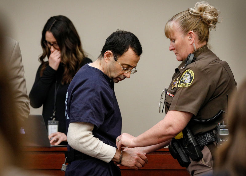 © Reuters. Larry Nassar, a former team USA Gymnastics doctor, who pleaded guilty in November 2017 to sexual assault charges, is handcuffed in the courtroom at the end of a day of testimony during his sentencing hearing in Lansing, Michigan