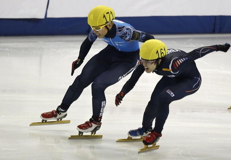 © Reuters. Viktor Ahn of Russia and Da Woon Sin of South Korea compete in the men's 1500m final race during the ISU Short Track World Cup speed skating competition in Shanghai