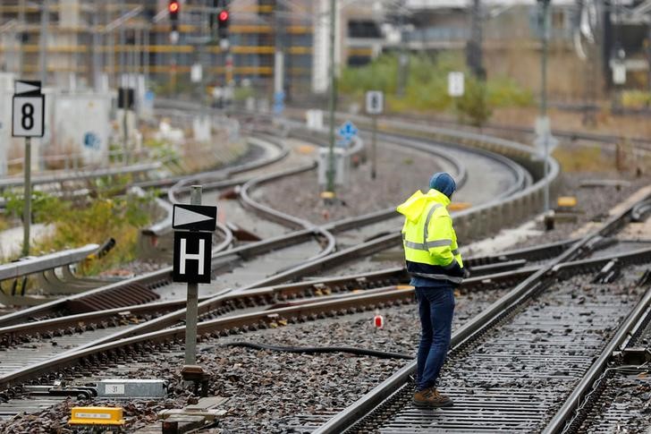 © Reuters. A man inspects the rails at the railway station Ostbahnhof in Berlin