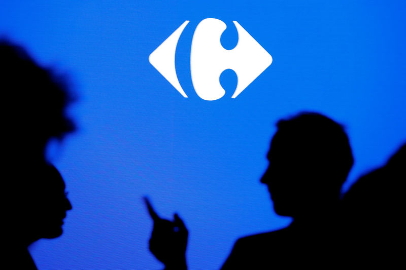 © Reuters. People are silhouetted as they attend a news conference to present the strategic plan of French retailer Carrefour in La Defense