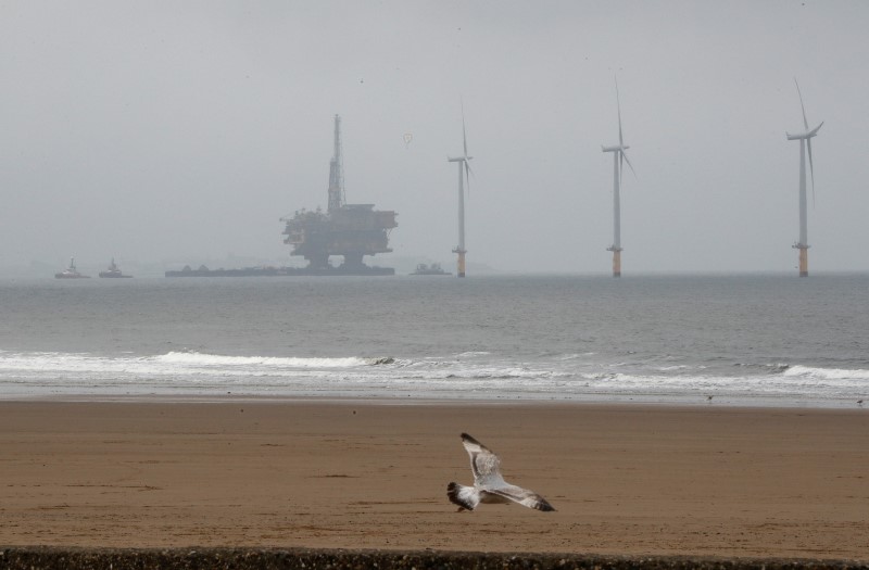 © Reuters. Shell's Brent Delta oil platform is towed past a windfarm into Hartlepool