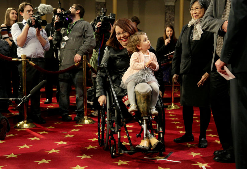 © Reuters. FILE PHOTO: Senator Duckworth (D-IL) carries her daughter Abigail during a mock swearing-in in Washington