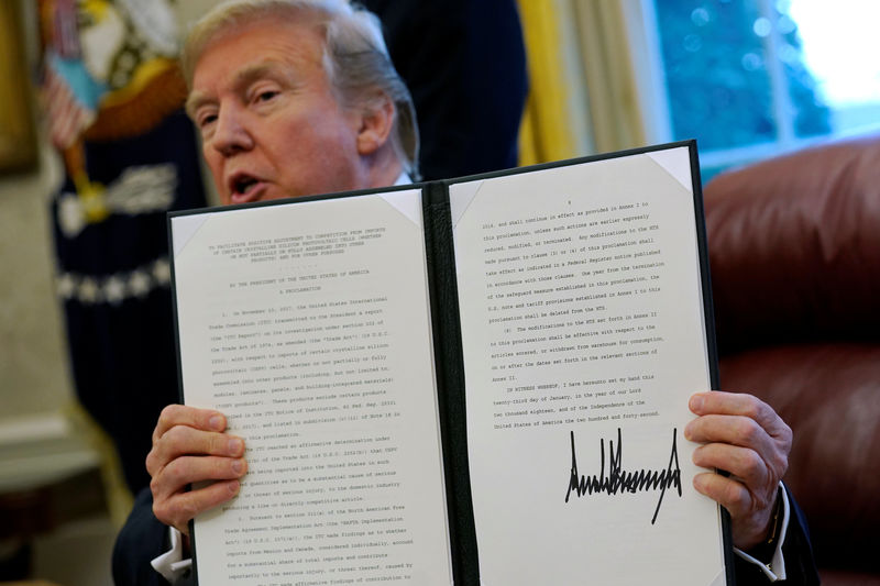 © Reuters. Trump signs directives to impose tariffs on washing machines and solar panels in the Oval Office at the White House in Washington