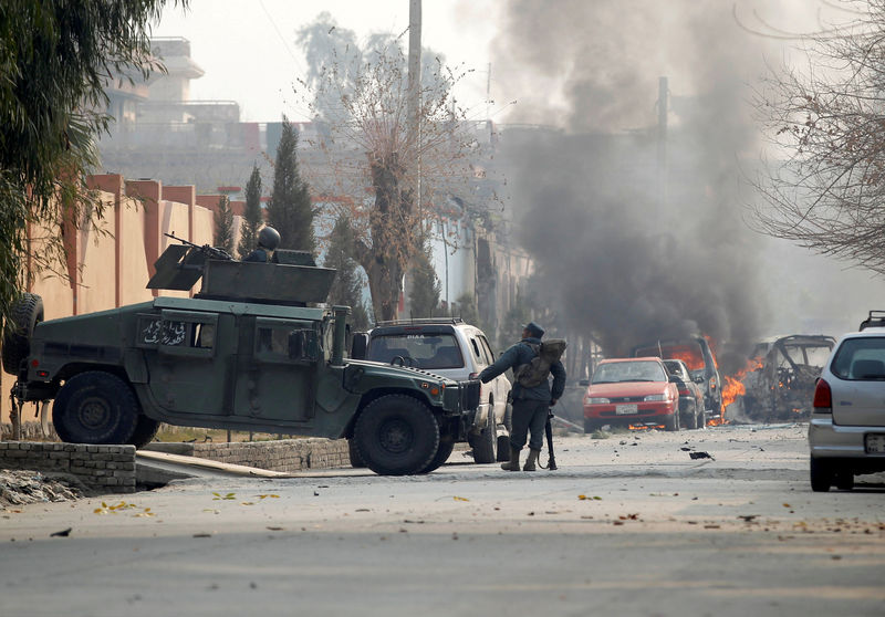 © Reuters. Afghan police officers arrive at the site of a blast and gun fire in Jalalabad