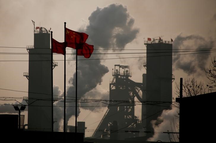 © Reuters. FILE PHOTO: Chinese national flags flutter near a steel factory in Wu'an