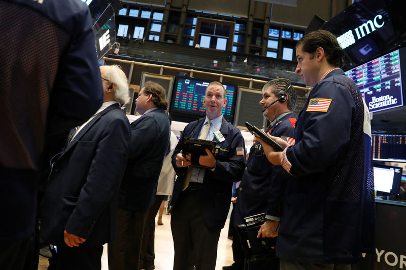 © Reuters. FILE PHOTO: Traders work on the floor of the New York Stock Exchange shortly after the opening bell in New York