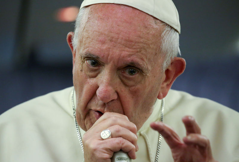 © Reuters. Pope Francis gestures during a news conference on board of the plane during his flight back from a trip to Chile and Peru