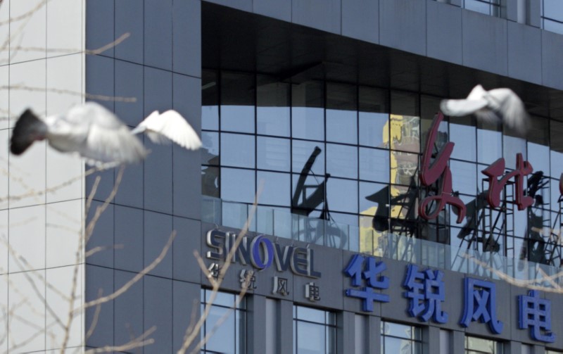 © Reuters. Pigeons fly past the company logo of Sinovel Wind Co., Ltd. outside its head office in Beijing