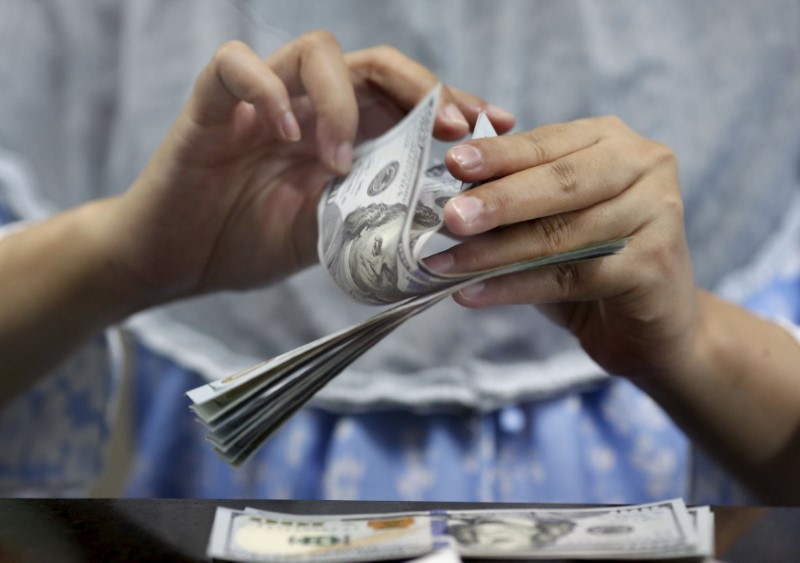 © Reuters. A teller counts U.S. dollars at a money changer in Jakarta, Indonesia