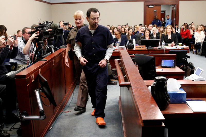 © Reuters. FILE PHOTO: Larry Nassar, a former team USA Gymnastics doctor who pleaded guilty in November 2017 to sexual assault charges, is escorted into the courtroom during his sentencing hearing in Lansing
