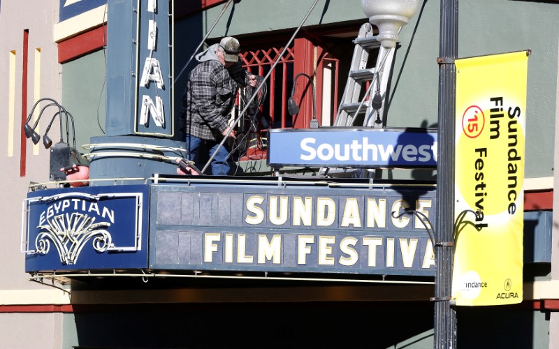 © Reuters. FILE PHOTO: Barker makes repairs to the neon sign at the Egyptian Theatre at the Sundance Film Festival in Park City