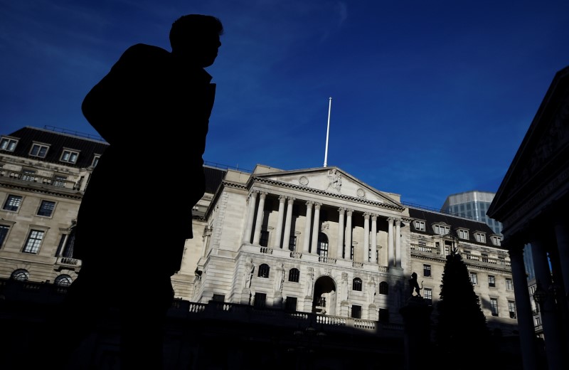 © Reuters. FILE PHOTO: A man is silhouetted as he walks past the Bank of England in the City of London