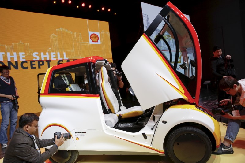 © Reuters. People take pictures of a high-efficiency petrol-burning concept car as it is unveiled by Royal Dutch Shell during a ceremony in Beijing