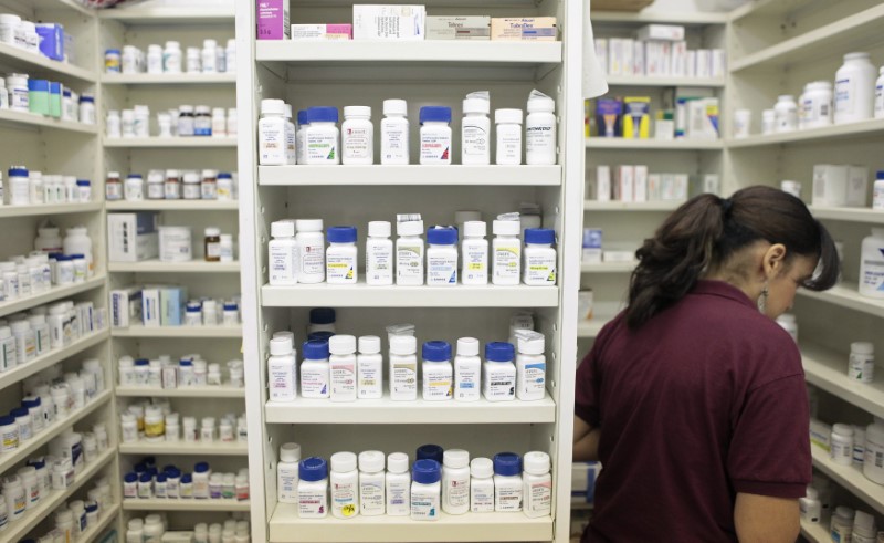 © Reuters. A pharmacy employee looks for medication as she works to fill a prescription while working at a pharmacy in New York