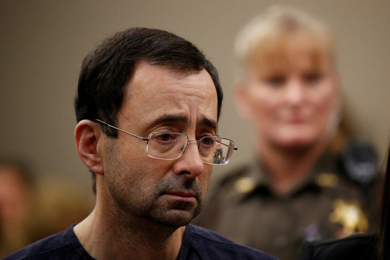 © Reuters. FILE PHOTO:    Larry Nassar, a former team USA Gymnastics doctor who pleaded guilty in November 2017 to sexual assault charges, stands with his legal team during his sentencing hearing in Lansing