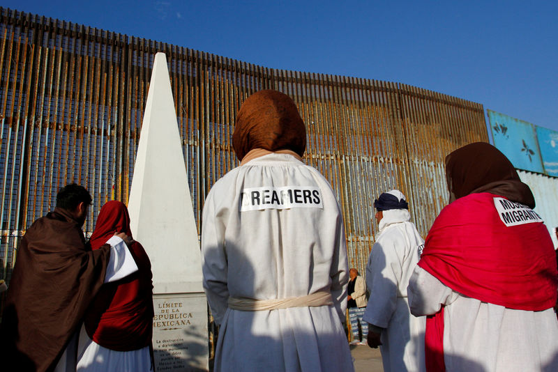 © Reuters. FILE PHOTO:  "Dreamers" stand near the double steel fence that separates the U.S and Mexico at the border in Tijuana