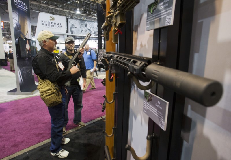 © Reuters. Chadwick and son Joshua of Triple J Firearms look over Remington rifles and shotguns during SHOT Show in Las Vegas